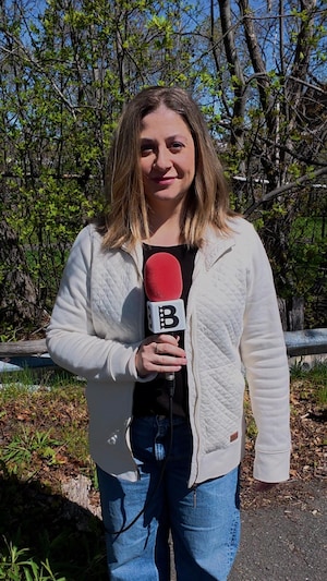 Emmanuelle Robinson tient un microphone.