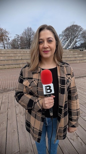 Emmanuelle Robinson tient un microphone.