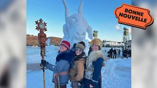 Trois femmes posent devant une sculpture de neige d'une vache aquatique.