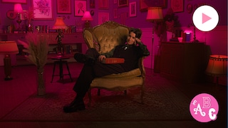 Alex Lacelle est assis dans une chaise dans une chambre décorée de cadres. Le logo de la série L'ABC Intimité et le bouton Jouer sont à droite.