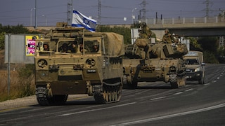 Des tanks de l'armée israélienne se déplacent vers la frontière de Gaza. Un d'eux porte le drapeau israélien. 