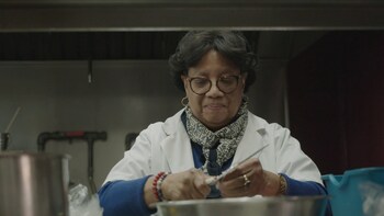Une personne coupe des oignons dans la cuisine commerciale de son magasin.  