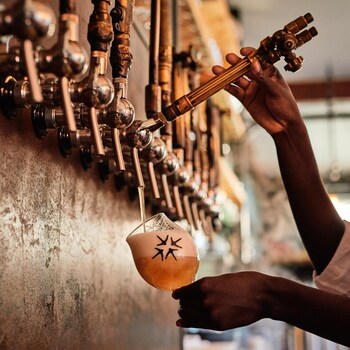 Une personne sert un verre de bière en fût.