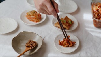 Des petites assiettes de céramique contenant de la pâte différents accompagnements coréens.