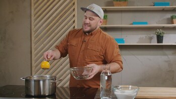 Rémy Couture qui tient dans une main un bol et dans l'autre une cuillère. 