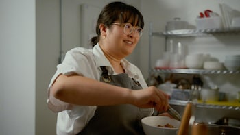 Anita Feng en train de préparer une recette dans une cuisine.