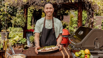 Le chef Minh Phat Tu dans une cuisine extérieure devant son plat de thon albacore.