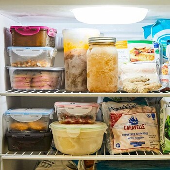 L'intérieur d'un congélateur avec divers aliments congelés.