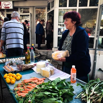 Femme qui vend des légumes dans un marché croate.