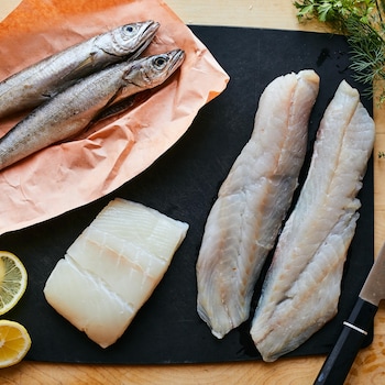 3 espèces de poissons du Saint-Laurent crus disposés sur une planche. 
