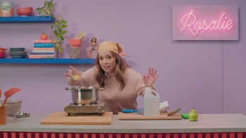 Rosalie s'apprête à déposer un œuf dans une chaudron d'eau bouillante. 