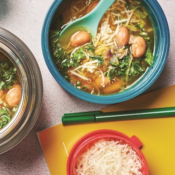 Deux bols de soupe à la courge spaghetti et au kale sur sur un comptoir.