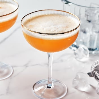 Un cocktail moussé à la clémentine dans une coupe.