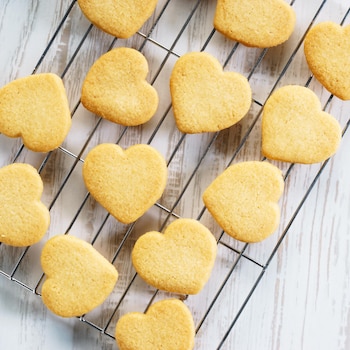 Des biscuits sablés en forme de cœur sur une grille.