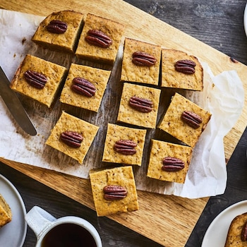 Des biscuits à la citrouille sur une planche en bois et dans quelques assiettes.