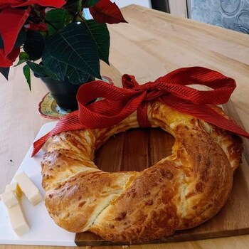 Une couronne de pain brioché décorée d'une boucle rouge. 