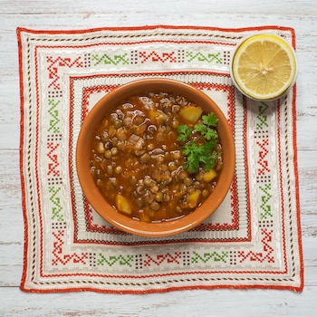 Un bol de lentilles marocaines servi avec un demi citron.