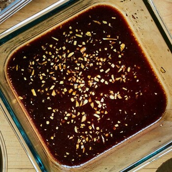 Un bol contenant la marinade au miel et à l'ail sur un comptoir.