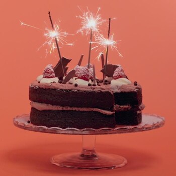 Un gâteau au chocolat avec des bougies scintillantes. 
