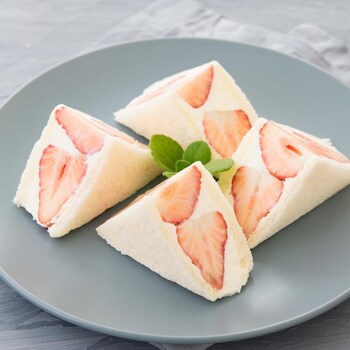 Un sandwich japonais aux fraises coupé en triangles dans une assette.