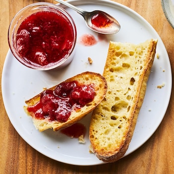 Tartinade aux fraises réduite en sucre sur un pain dans une assiette.