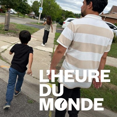 Le père et ses deux enfants traversent une rue résidentielle. Au bas de l'image, on voit le logo de l'émission L'heure du monde.