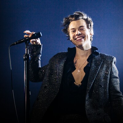 Harry Styles, souriant, devant un micro.