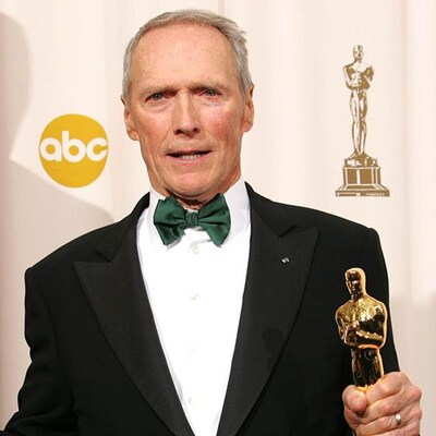 Clint Eastwood qui tient deux oscars dans ses mains, lors de la cérémonie des Oscars en 2005. 