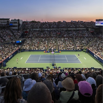 Photo d'un terrain de tennis extérieur (le Court central) au Stade du parc Jarry, les gradins pleins.
