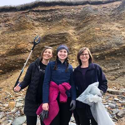 Trois femmes qui ramassent des déchets sur une plage.