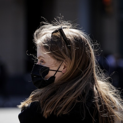 Une femme portant un masque dans la rue à Toronto.