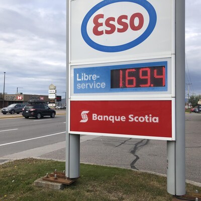 Une affiche de prix de l'essence sur un boulevard.