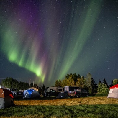 Les évacués de Yellowknife, capitale territoriale des Territoires du Nord-Ouest, sont accueillis par des aurores boréales à leur arrivée dans un camping gratuit fourni par la communauté à High Level, en Alberta, le jeudi 17 août 2023.