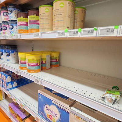 Un étalage est rempli de plusieurs contenants de lait maternisé de différentes marques.
