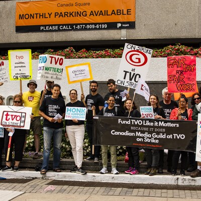 Des employés de TVO membres de la de la Guilde canadienne des médias manifestent devant leurs bureaux à l'intersection de la rue Yonge et de l'avenue Eglinton en brandissant des affiches le 12 septembre.