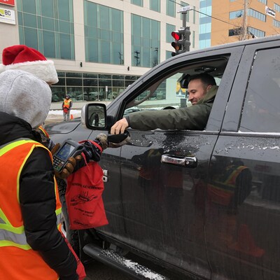 Un homme dans sa camionnette fait un don à des bénévoles.