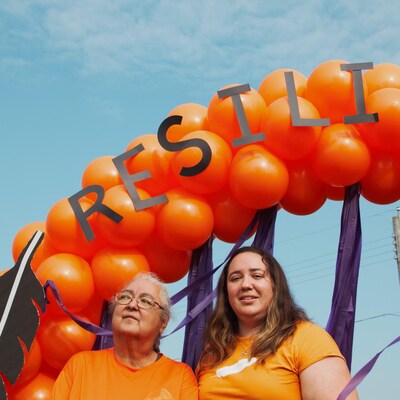 Deux femmes sous une arche de ballons.