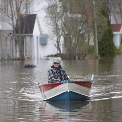 Un homme circule à bord d'une chaloupe dans les rues de Gatineau.