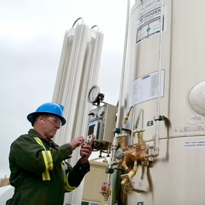 Un technicien travaillant sur un réservoir d'azote liquide destiné à remplacer le méthane sur les sites de forage.