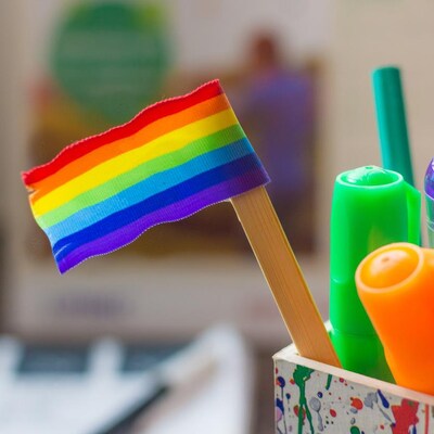 Un drapeau de la fierté LGBTQ+ dans un coffre à crayons dans une salle de classe.