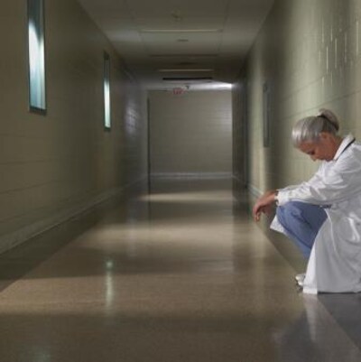 Une femme médecin est accroupie dans le corridor d'un hôpital.