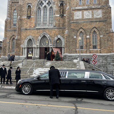 Un corbillard arrive devant une église.