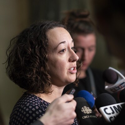 Nicole Sarauer au milieu d'une mêlée de presse à l'Assemblée législative.