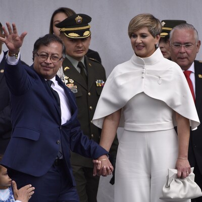 Le président colombien Gustavo Petro salue des partisans aux côtés de son épouse Veronica Alcocer sur une estrade.