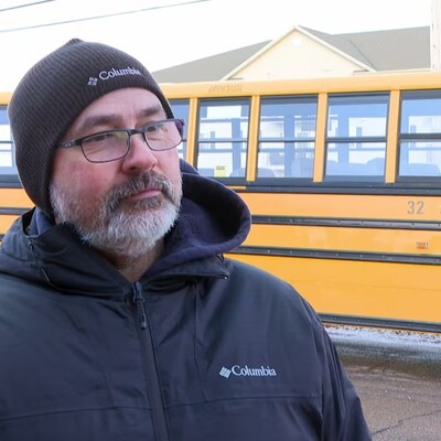 Rob Harding devant un autobus. 
