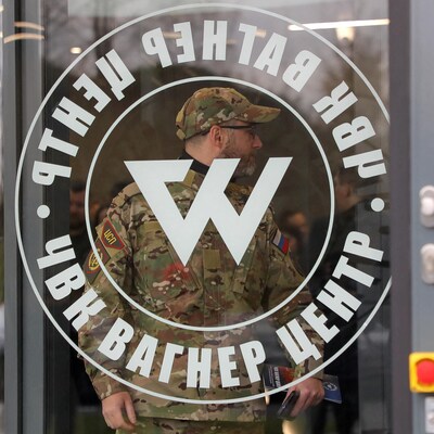 Un homme portant un uniforme de camouflage entre dans les bureau du groupe militaire privé Wagner, à Saint-Pétersbourg.
