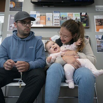 Un couple dans une salle d'attente avec leur bébé.
