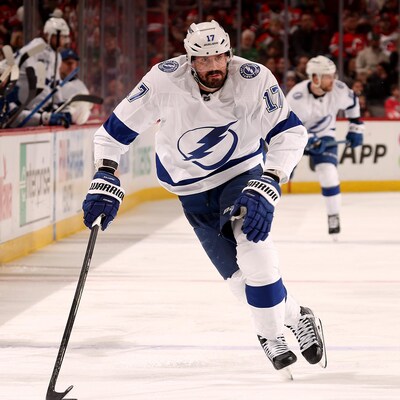 L'attaquant Alex Killorn, en blanc, transporte la rondelle pendant un match. 