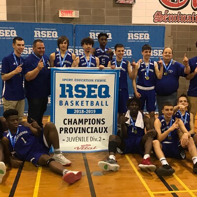 Des joueurs de basketball célèbrent une victoire avec la bannière de champion.