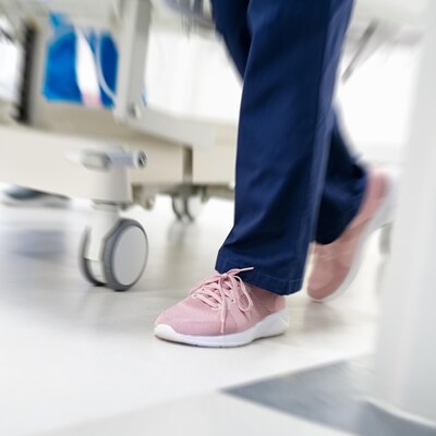 Une infirmière se déplace dans un corridor. 
